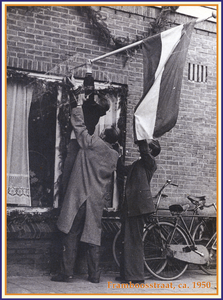 862140 Afbeelding van twee leden van de straatvereniging Framboosstraat te Utrecht, die de vlag uitsteken voor het ...